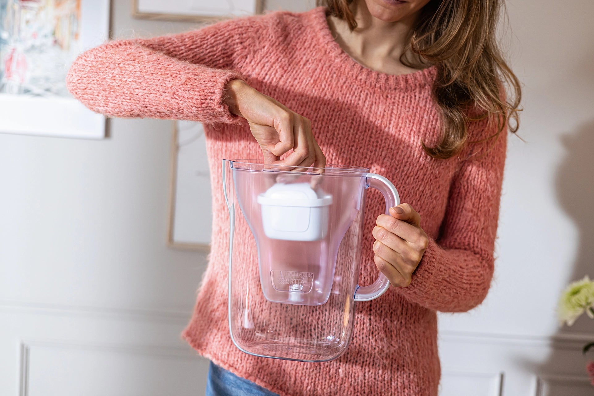Person inserting MAXTRA filter cartridge in BRITA water filter jug Style Essential.