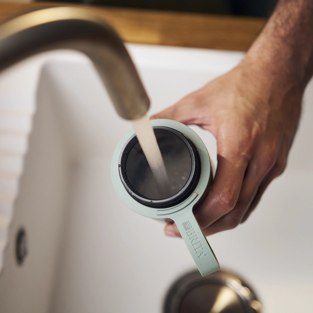 Filling water in green BRITA water filter bottle Model Active