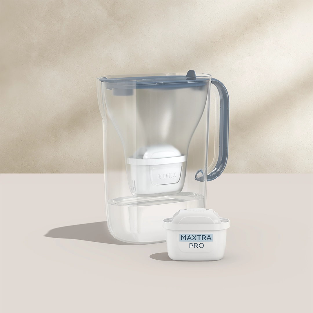 BRITA Style Essential in blue with a MAXTRA PRO filter cartridge on a beige background.