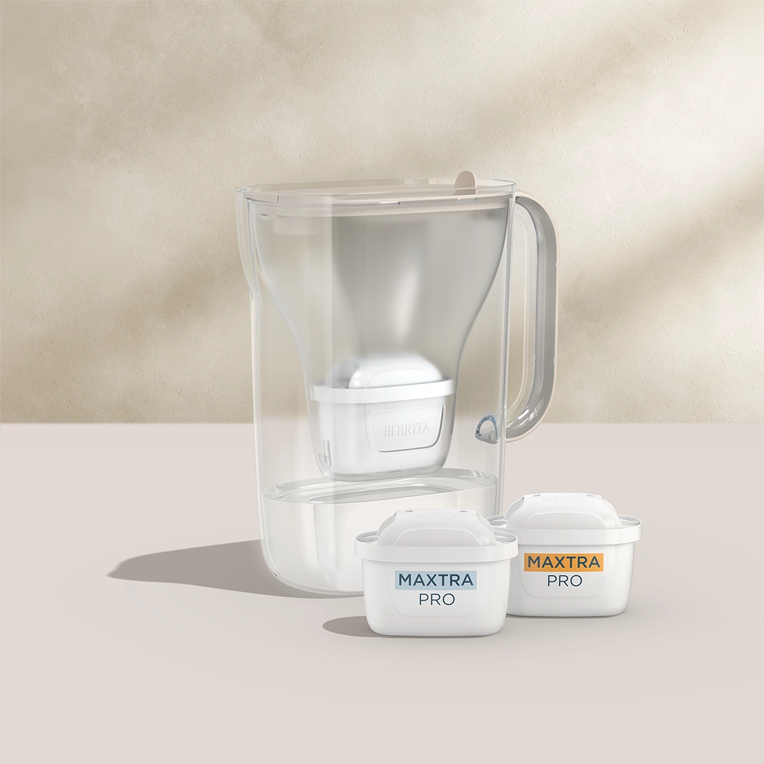 BRITA Style Essential in sand with two MAXTRA PRO filter cartridges on a beige background.