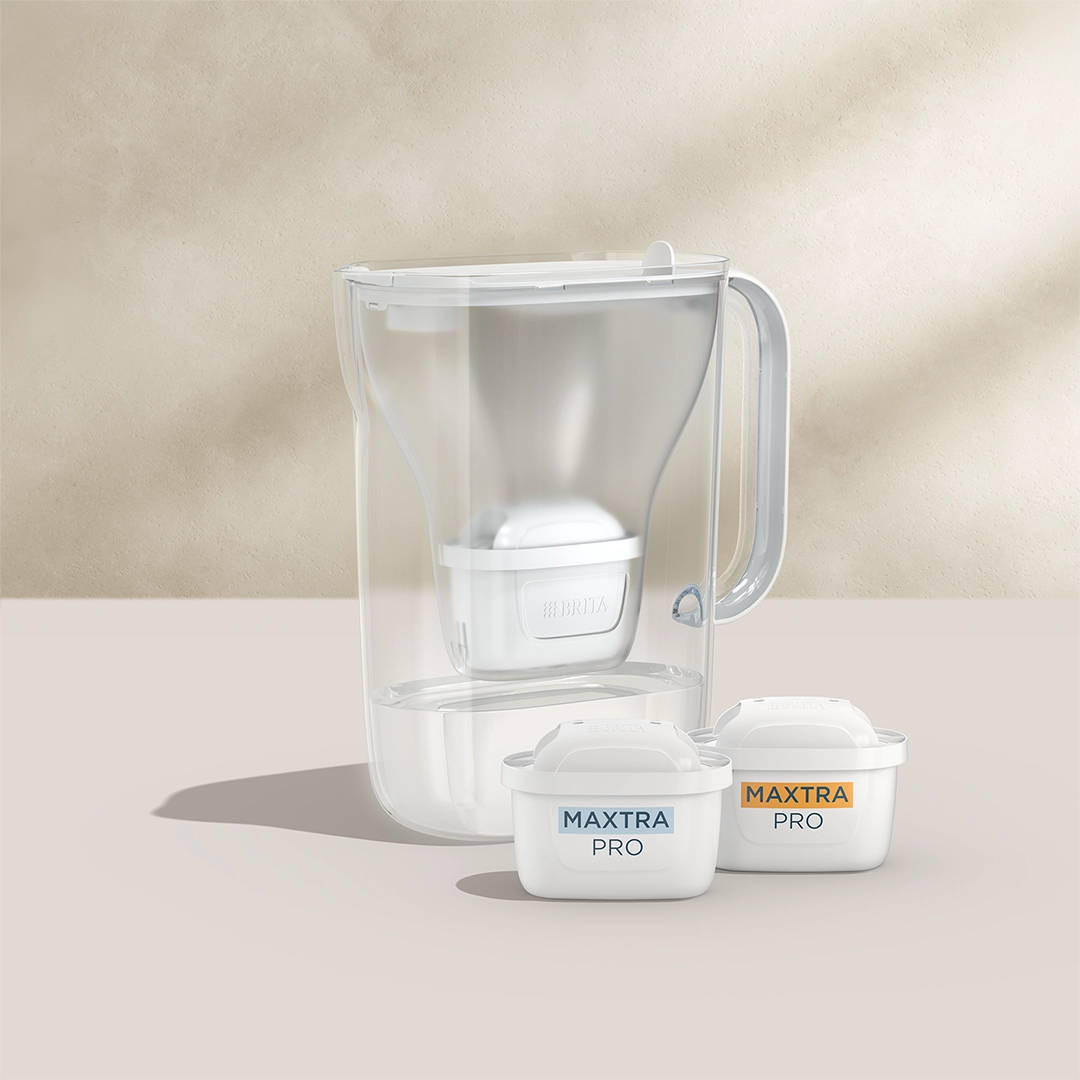 BRITA Style Essential in white with two MAXTRA PRO filter cartridges on a beige background.