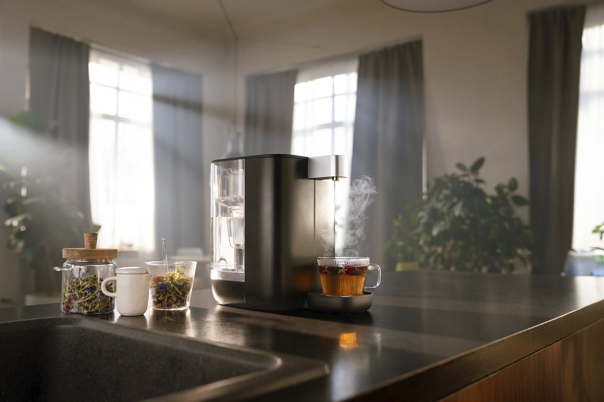 BRITA YOURCE mini water dispenser with a freshly prepared cup of tea and loose tea ingredients.